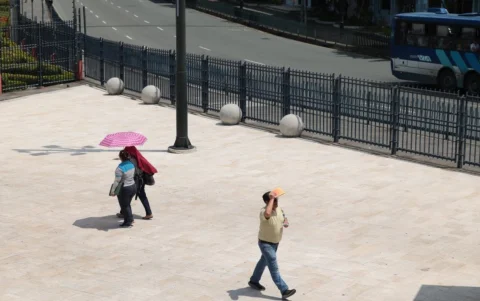 Ciudadanos en el centro de Guayaquil utilizan sombrillas y gorras para protegerse del alto índice de radiación UV que golpea a la urbe.