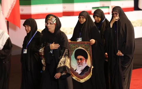 Mujeres sosteniendo un retrato del difunto Líder Supremo de Irán, el ayatolá Alí Jameneí, rinden homenaje junto a su féretro en Teherán, Irán, el 3 de julio de 2026.