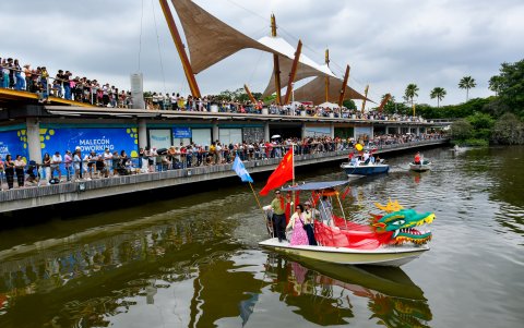 El paso del bote del Drágón estuvo escoltado por jóvenes de la escuela de remo del Guayas.