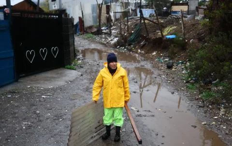 Una persona reacciona en un campamento que presenta riesgo de inundación por el temporal en la rivera del río Mapocho.