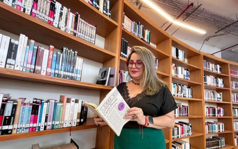 Siomara España, rebuscando entre los cientos de libros de la colección de la Biblioteca de las Artes