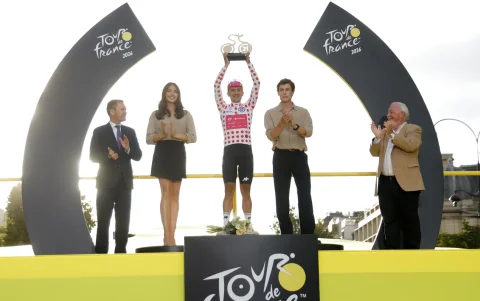 Richard Carapaz posa con el trofeo al ciclista más combativo del Tour de Francia 2026 y el maillot de la montaña.