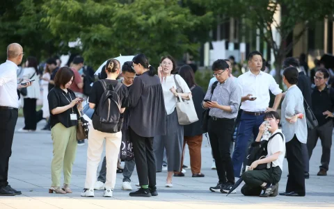 Varias personas se congregan frente a un edificio tras un potente terremoto en la ciudad de Kumamoto, Japón, el 28 de julio de 2026.