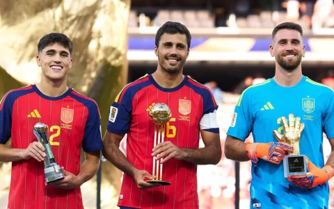 Rodri, Unai Simón (der) y Ferran Torres (izq) posan con los premios individuales obtenidos durante la ceremonia de clausura del Mundial 2026.