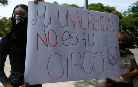 Estudiantes de la Universidad Santiago de Cali sostienen un cartel durante una manifestación en contra de la posesión presidencial