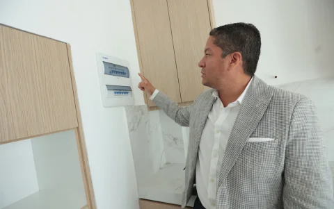 El arquitecto Andrés Muñoz muestra el sistema que maneja el uso de los paneles solares y el banco de energía.