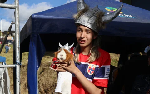 David Guerrero junto a su cuy (conejillo de Indias) disfrazado como el futbolista de la selección de Noruega Eerling Haaland.