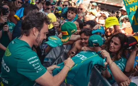 Fernando Alonso comparte un momento con aficionados de Aston Martin durante un evento del equipo.