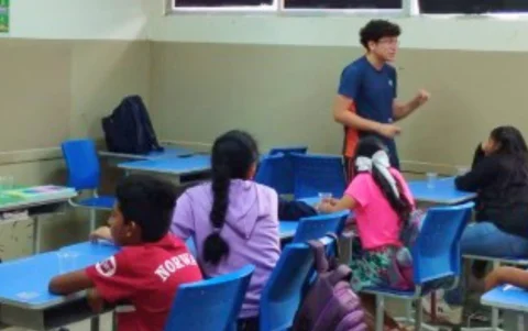 Jorge Johnston, estudiante de la Unidad Educativa Copol, da clases de nivelación a niños como parte del programa Mi hermano mayor.