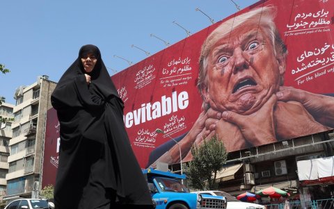 Una mujer camina junto a una valla publicitaria contra Trump en Teherán, 19 de agosto de 2026.