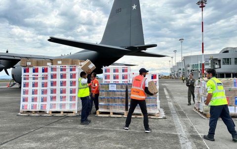 Grupo de trabajadores descargando ayuda humanitaria llegada desde Chile al aeropuerto Matecaña de Pereira (Colombia).