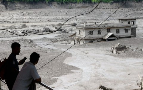 La gente observa cómo las aguas de la inundación arrasan Trishuli Bazar tras una crecida repentina, en el distrito de Nuwakot, Nepal, el 26 de agosto de 2026.