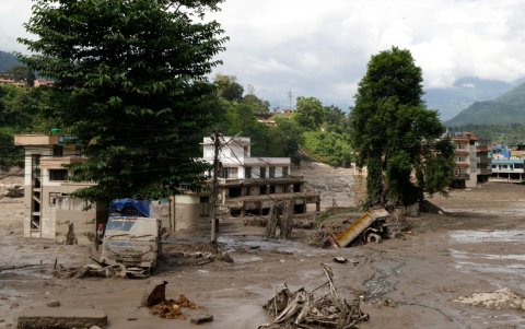 Los residentes observan las casas parcialmente sumergidas en agua lodosa tras las inundaciones repentinas en Trishuli Bazar, en el distrito de Nuwakot, Nepal, el 26 de agosto de 2026.