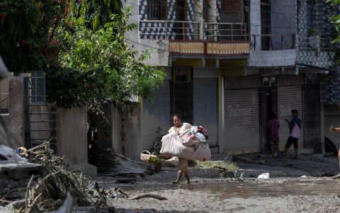 Los supervivientes de las inundaciones regresan a sus hogares tras una crecida repentina en la aldea de Devighat, distrito de Nuwakot, Nepal, el 27 de agosto de 2026.