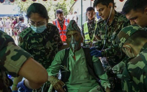 Sobrevivientes de inundaciones repentinas reciben atención médica en una base militar en el distrito de Nuwakot.