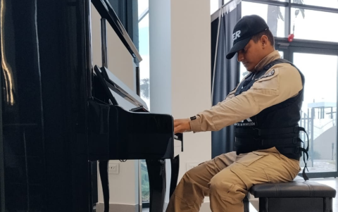 Billy Asencio toca piano en el Onco Center de la UEES, antes de recibir la beca.