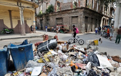 Personas caminan frente a basura acumulada por la falta de combustible para su recolección el 28 de agosto de 2026, en La Habana (Cuba).