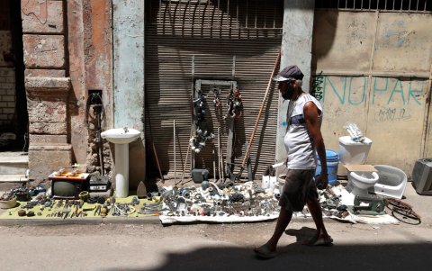 Una persona camina frente a una venta de artículos usados, este martes en La Habana (Cuba).