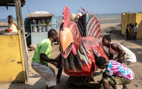 Eric Adotey Kpakpo y los trabajadores de su tienda llevan un ataúd con forma de pollo, diseñado en referencia a la profesión del fallecido, un granjero.