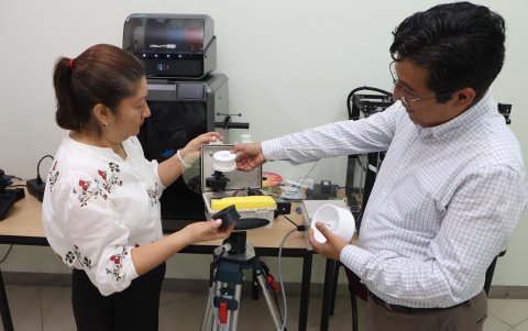 Adriana Collaguazo (izq.) y Daniel Ochoa muestran la trampa de esporas desarrollada por la ESPOL.