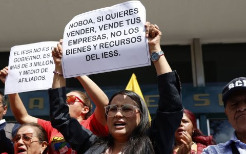 Manifestantes sostienen carteles durante el plantón en Quito, con mensajes en defensa de los recursos y la autonomía del IESS.