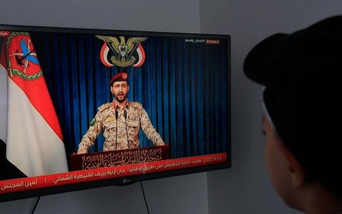 Una persona observa al portavoz militar hutí Yahya Sarea pronunciar una declaración televisada en Saná, Yemen, el 8 de septiembre de 2026.