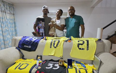 Los padres de Doménica, junto a su hermano y su pequeño cachorro, posan junto a las camisetas y medallas que la futbolista les ha obsequiado y que guardan como recuerdos de su carrera