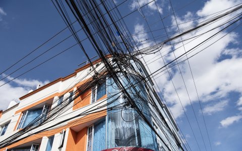 Cables colgados atraviesan las calles de Cumbayá y pasan cerca de viviendas, mientras vecinos piden ordenar las redes de telecomunicaciones existentes.