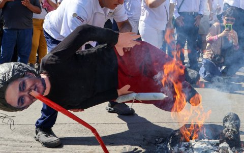 Un hombre sostiene una imagen alusiva a la presidenta de México, Claudia Sheinbaum, durante la marcha.