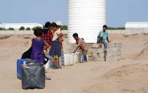Personas desplazadas recogen agua de una tubería donada en un campamento improvisado en la ciudad de Adén, en el sur de Yemen, el 14 de septiembre de 2026.