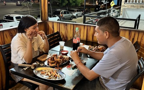 Una pareja disfruta de un combo de cangrejos criollos en una cangrejería de Sauces 9, tras el fin de la veda del cangrejo rojo.