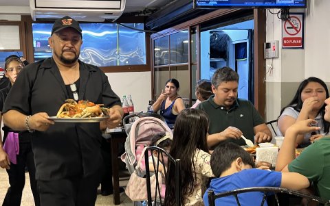 Un mesero lleva una bandeja con cangrejos a los comensales que acudieron al Cangrejal D'Leito, en Sauces 9.