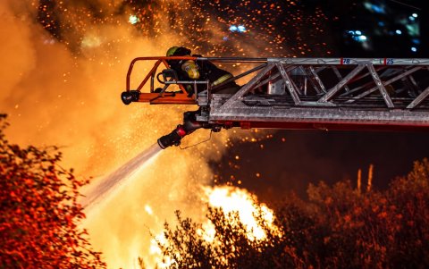 Personal bomberil intenta sofocar las llamas en el sector de La Vicentina, cerca de la avenida Velasco Ibarra, en Quito, la noche de este miércoles 16 de septiembre.