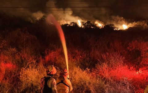 Bomberos de Quito intentan sofocar las llamas en el cerro Casitagua.