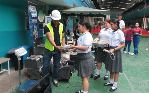 Estudiantes llevan aparatos eléctricos y electrónicos que ya no utilizan en sus hogares para entregarlos en el colegio.