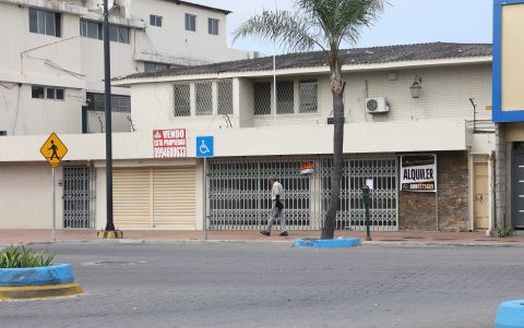 Cerca de un centro comercial hay inmuebles con letreros que indican que se venden o alquilan.