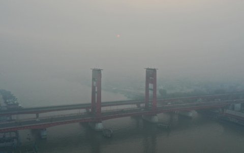 Una vista aérea muestra una espesa neblina procedente de los incendios forestales que envuelven el puente Ampera en Palembang, Sumatra del Sur, Indonesia.