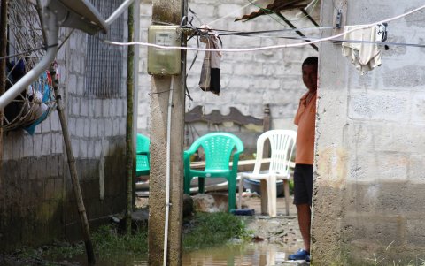 Un morador permanece dentro de su vivienda, rodeado por el agua acumulada tras las fuertes lluvias que afectaron a La Unión, en Quinindé.