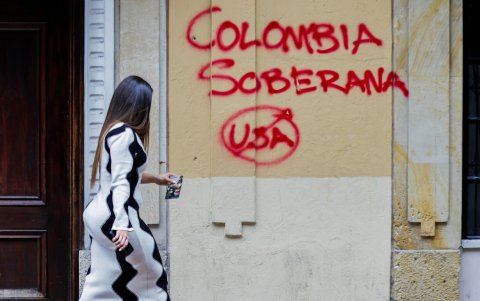 Una mujer camina frente a un grafiti en el que se lee “Colombia Soberana” este lunes, en Bogotá (Colombia).
