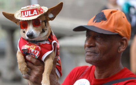 Un hombre sostiene a su mascota durante un acto de campaña del presidente de Brasil y candidato a la reelección, Luiz Inácio Lula da Silva.