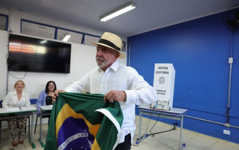 El presidente de Brasil y candidato a la reelección, Luiz Inácio Lula da Silva, sostiene la bandera nacional tras votar este domingo en un colegio electoral en la ciudad de São Bernardo do Campo.