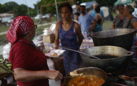 Una mujer sirve alimentos a personas en un parque este sábado, en el centro de Tonosí (Panamá).