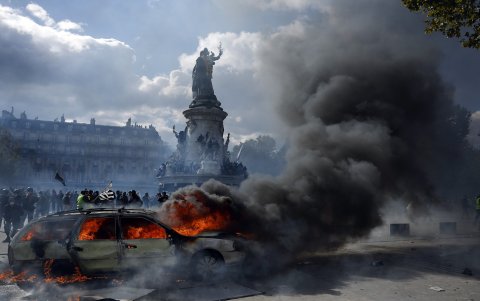 Un automóvil arde en la plaza de la República mientras estallan enfrentamientos entre manifestantes y la policía durante una protesta contra el aumento del coste de la vida en París.