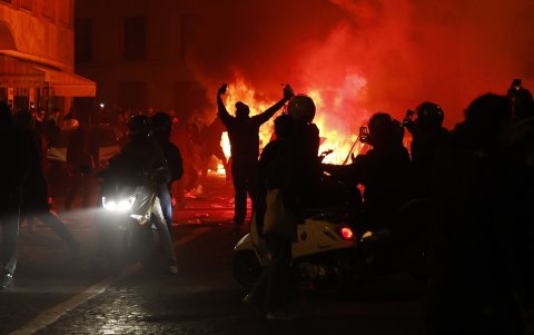 Manifestantes prenden fuego frente a una tienda de comestibles cerca de los Campos Elíseos durante una manifestación en París, Francia.