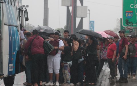 Bajo la lluvia y con la mirada puesta en la llegada del transporte público, los guayaquileños intentaron continuar con sus actividades pese a las complicaciones de la mañana.