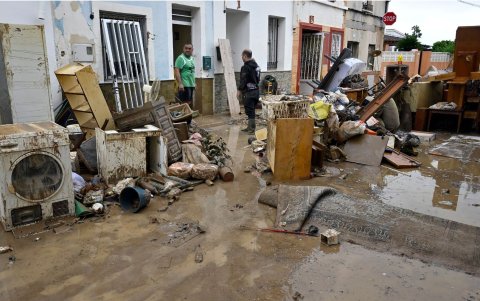 Dos personas permanecen de pie en una calle llena de escombros tras las inundaciones provocadas por lluvias torrenciales en Els Poblets