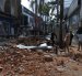 Personas caminan frente a una edificación afectada tras un fuerte temblor este lunes, en Manizales (Colombia)