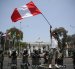 Fotografía de un hombre al ondear una bandera peruana, frente a la sede del Congreso Nacional de Perú, en Lima (Perú).