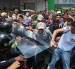 Personas exigen aumentos salariales mientras se enfrentan con integrantes de la policía en una manifestación este jueves, en Caracas (Venezuela).