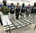 Agentes de Policía y Aduana exhiben el dinero y paquetes incautados durante el operativo en Quito.